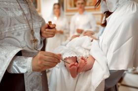 a priest anoints a baby s feet with oil