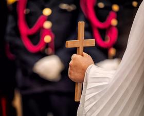 Angel holds a wooden crucifix during the celebration