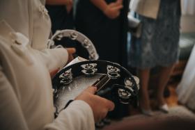 Closeup shot of two people sitting with tambourines in their hands at a wedding