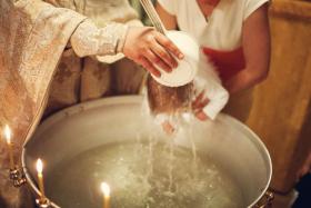 Orthodox Christian priest and little child in the church. Epiphany ceremony rite and font.